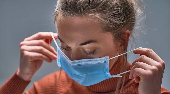 Healthy woman putting on medical protective mask to health protection and prevention during flu virus outbreak, epidemic and infectious diseases