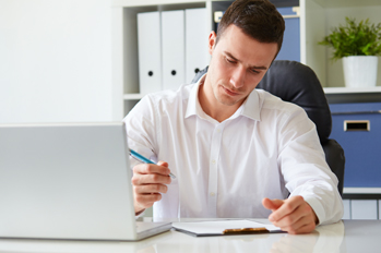 Young businessman signs a document at the office