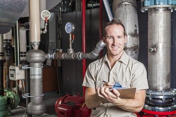 A Technician inspecting heating system in boiler room