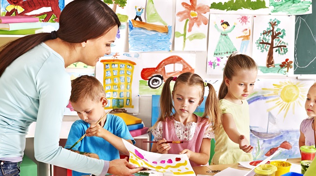 Happy children  with teacher at school.