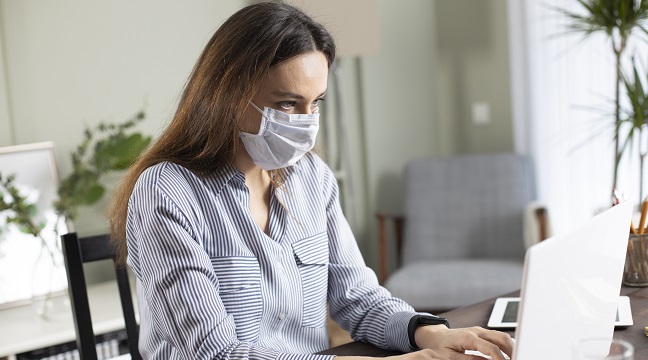 Business woman with mask working in the office on laptop. Concept, contagious disease, coronavirus. 